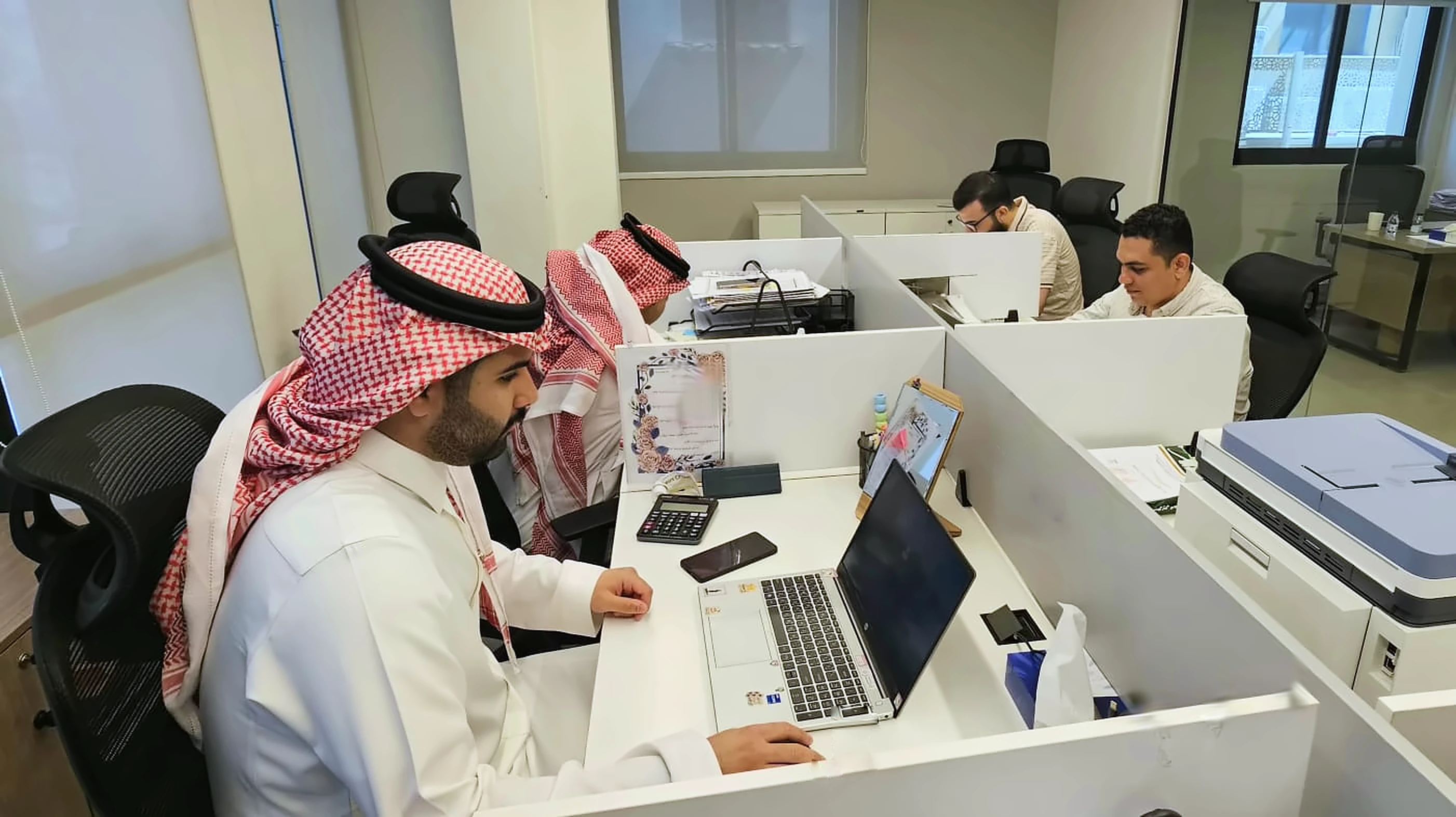 Colleagues working together at their desks in The Road's office